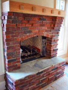 inside red brick fireplace wooden mantle