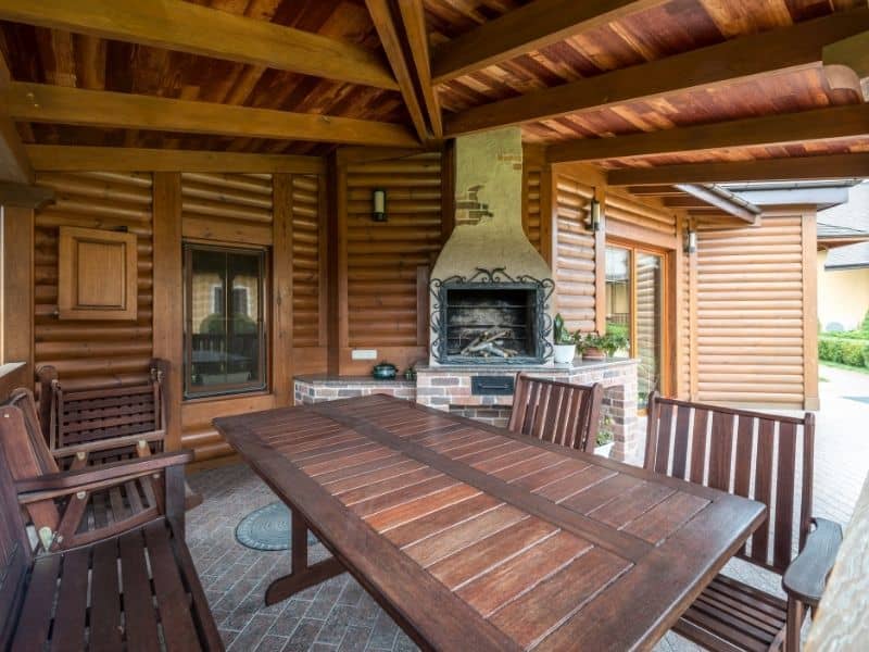 Outdoor fireplace beneath a covered roofline, showing how the chimney relates to the roof