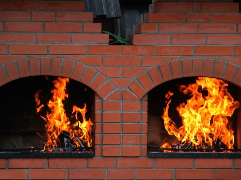 Double-sided brick fireplace with coordinated hearths in a Birmingham, Alabama, home, showing brick patterns, finished edges, and floor transitions between two rooms.