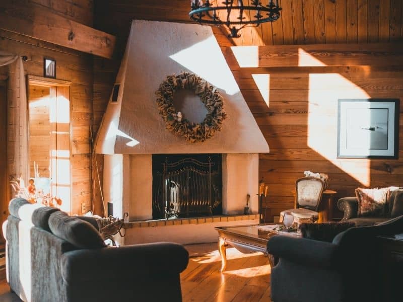 Corner fireplace with a custom stone hearth, angled firebox opening, coordinated masonry surround, and clear walking space in a Auburn living room.
