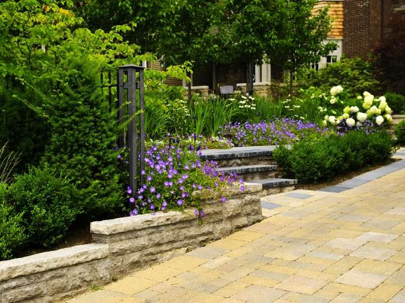 Stone paver courtyard at a hotel entrance with a welcoming walkway, landscaped borders, and smooth guest access in Auburn, Alabama.