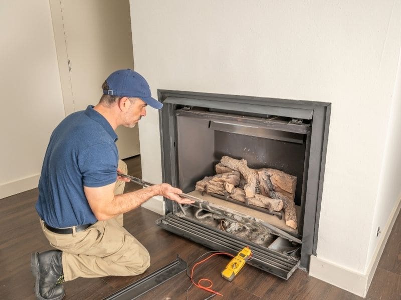 Fireplace repair before installing new glass doors showing firebrick mortar lintel and masonry around the opening.
